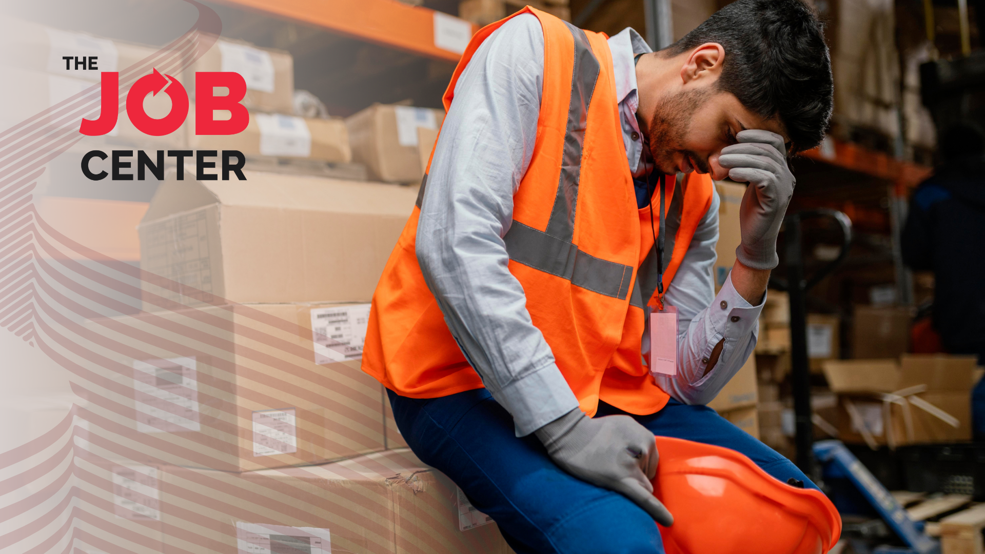 Overwhelmed warehouse worker sits on packaging boxes with head in hand