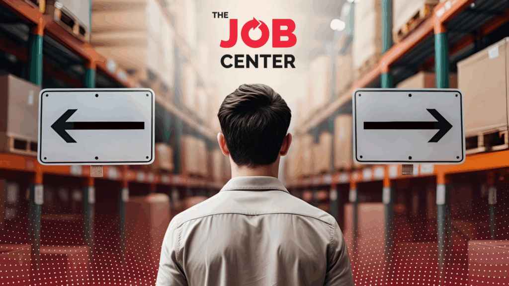 Warehouse worker stands at the edge of a warehouse looking at two signs pointing left and right